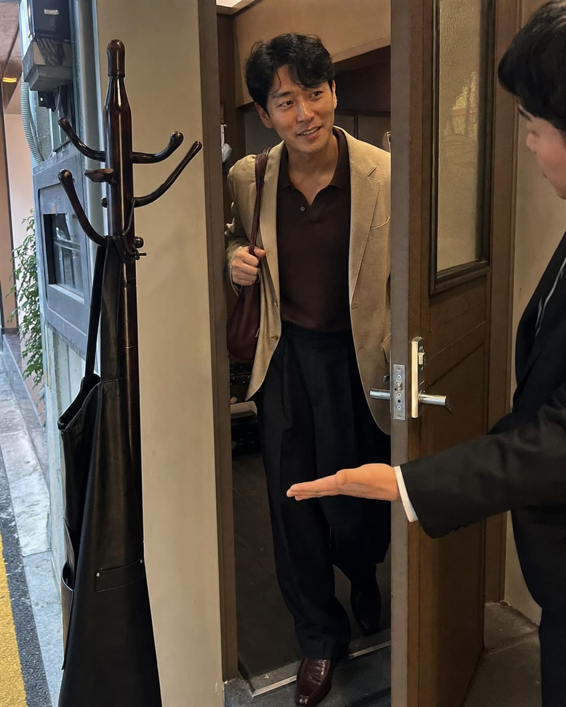 모임 장소 문 앞에서 맞이하는 손님과 도착자의 합성 콘셉트 장면